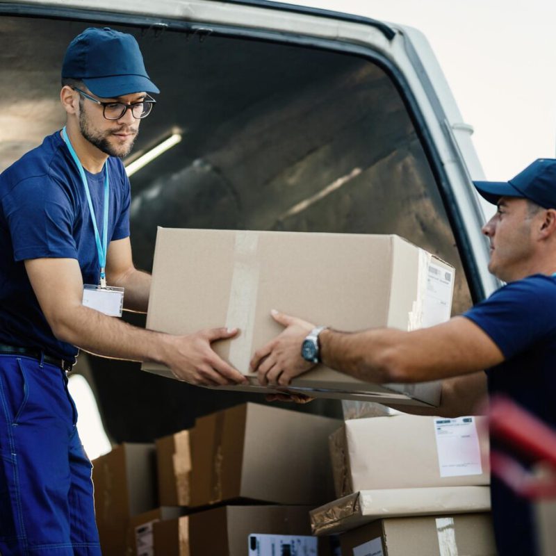 delivery-men-loading-carboard-boxes-van-while-getting-ready-shipment_637285-2289